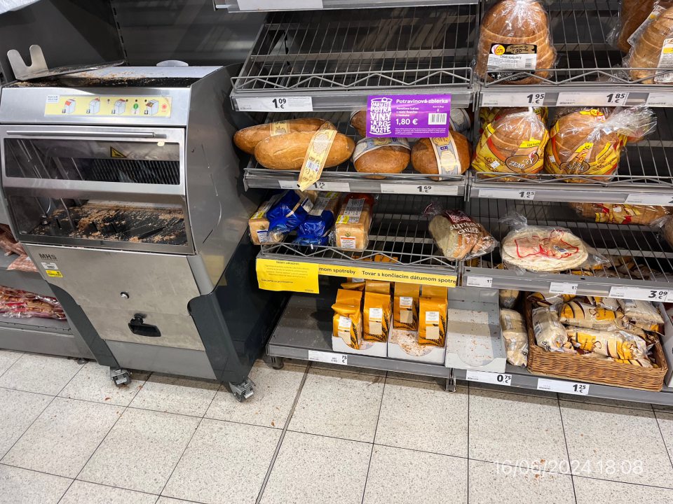 Regále a krájač chleba znečistený omrvinkami a zvyškami po krájaní.