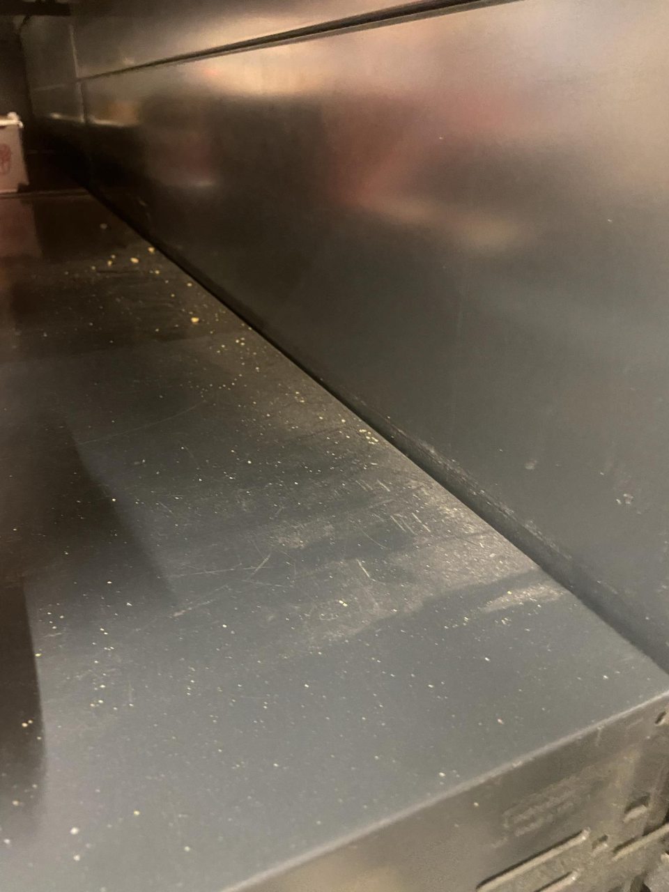 Regále na vystavovanie a predaj baleného pekárskeho polotovaru (hamburgery, tortilly) boli znečistené prachom a špinou.