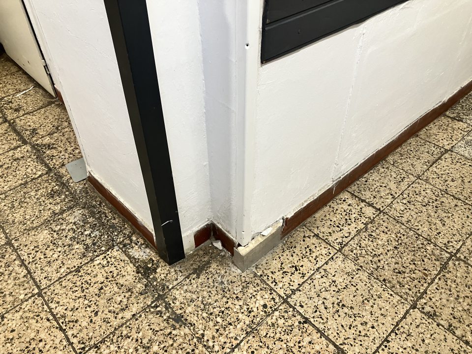 Zázemie prevádzky- odtrhnutá a poškodená kachlička v spodnej časti steny pri podlahe v manipulačnej miestnosti