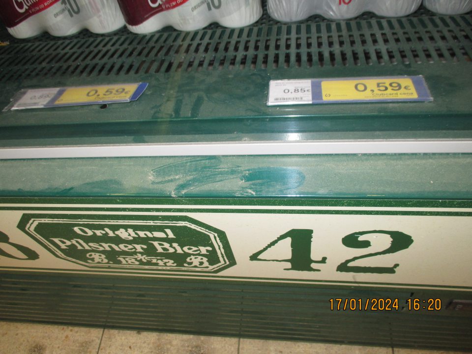 - na predajnej ploche, silne znečistený od prachu chladiarenský box s uloženým pivom 