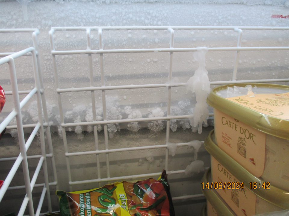 Zistený výskyt hrubej námrazy v mraziarenskom boxe s uloženými mrazenými krémami, nanukmi a hlbokozmrazenou zeleninou.