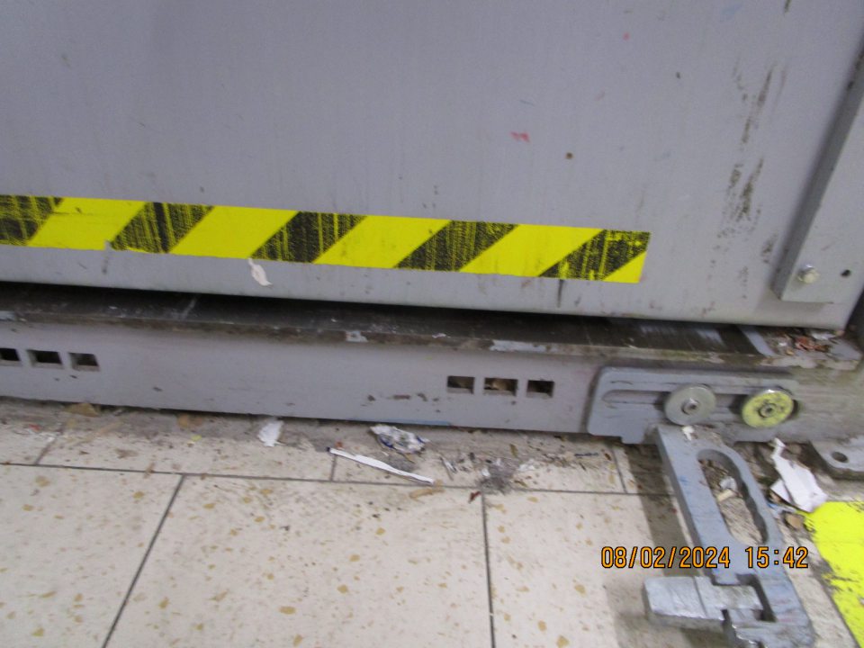 v zázemí za vstupnými dverami do skladovacích priestorov vpravo umiestnený lis na kartónové obaly znečistený nánosom prachu, nečistôt a časti kartónov