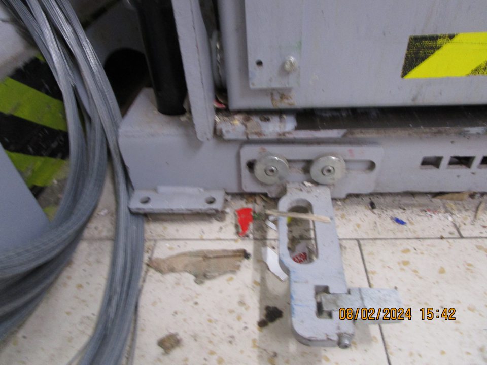 v zázemí za vstupnými dverami do skladovacích priestorov vpravo umiestnený lis na kartónové obaly znečistený nánosom prachu, nečistôt a časti kartónov