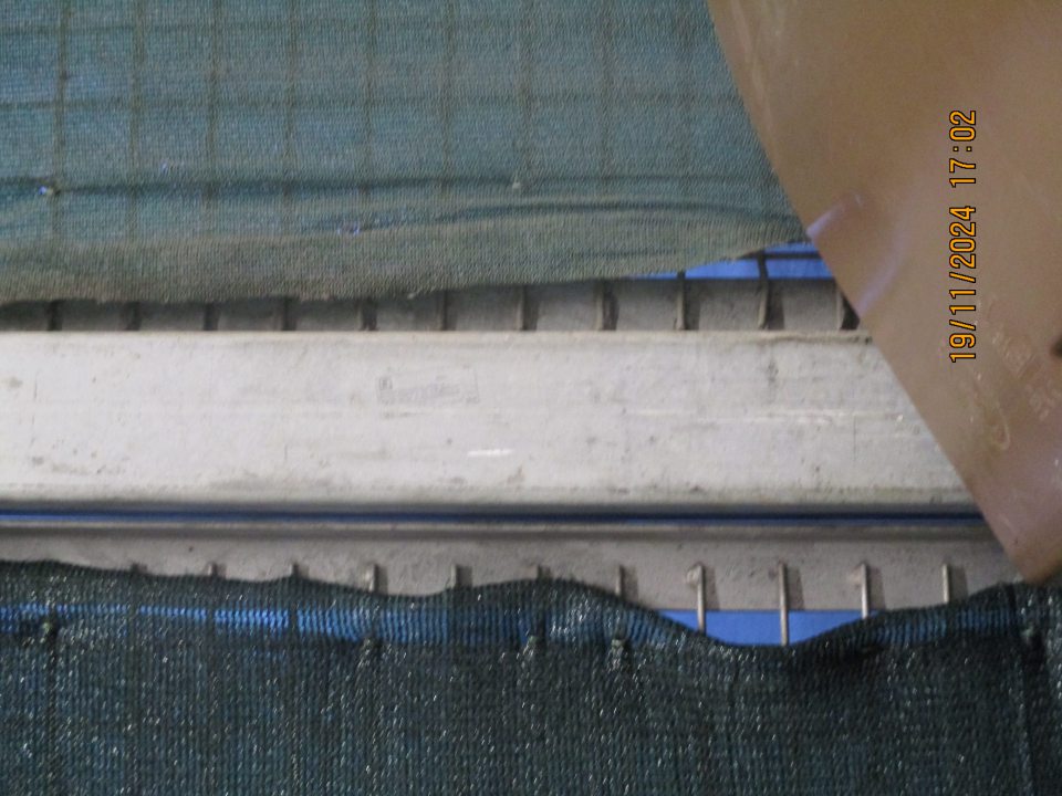 V časti príjmu potravín na kovovej mreži zistený výskyt nepriliehajúcej a poškodenej textílie na viacerých miestach o veľkosti cca 10 x10 cm s rizikom vnikunutia škodcov do vnútorných priestorov prevádzky