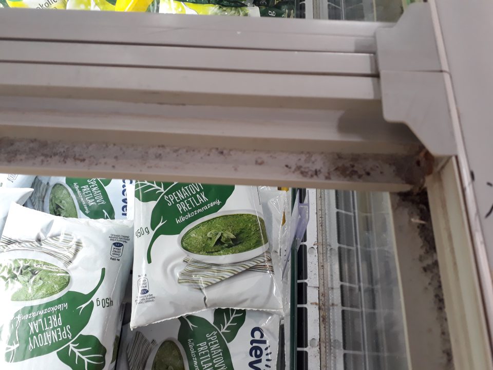 Vnútorné plochy a obvodové lišty sklenených dvierok stojacich mraziacich zariadení na predajnej ploche určené na skladovanie mrazených a hlbokozmrazených smotanových krémov, mrazenej zeleniny, polotovarov, hydiny a produktov rybolovu boli znečistené prachom a rozsypanými zvyškami potravín.