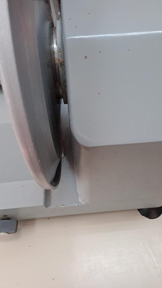 1. Znečistený nárezový stroj na mäsové výrobky zvyškami potravín.