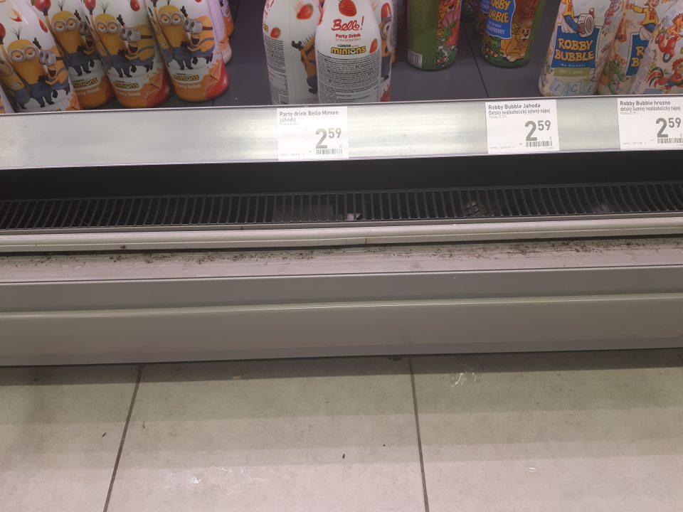 Znečistené chladiace vitríny na predajnej ploche určené na skladovanie alkoholických nápojov v spodnej časti rámu dvierok porastom čiernej plesne.