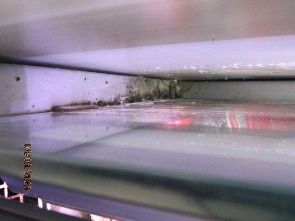 Pleseň, znečistenie a stekajúci kondenz na ľavej bočnej vonkajšej lište chladiaceho zariadenia