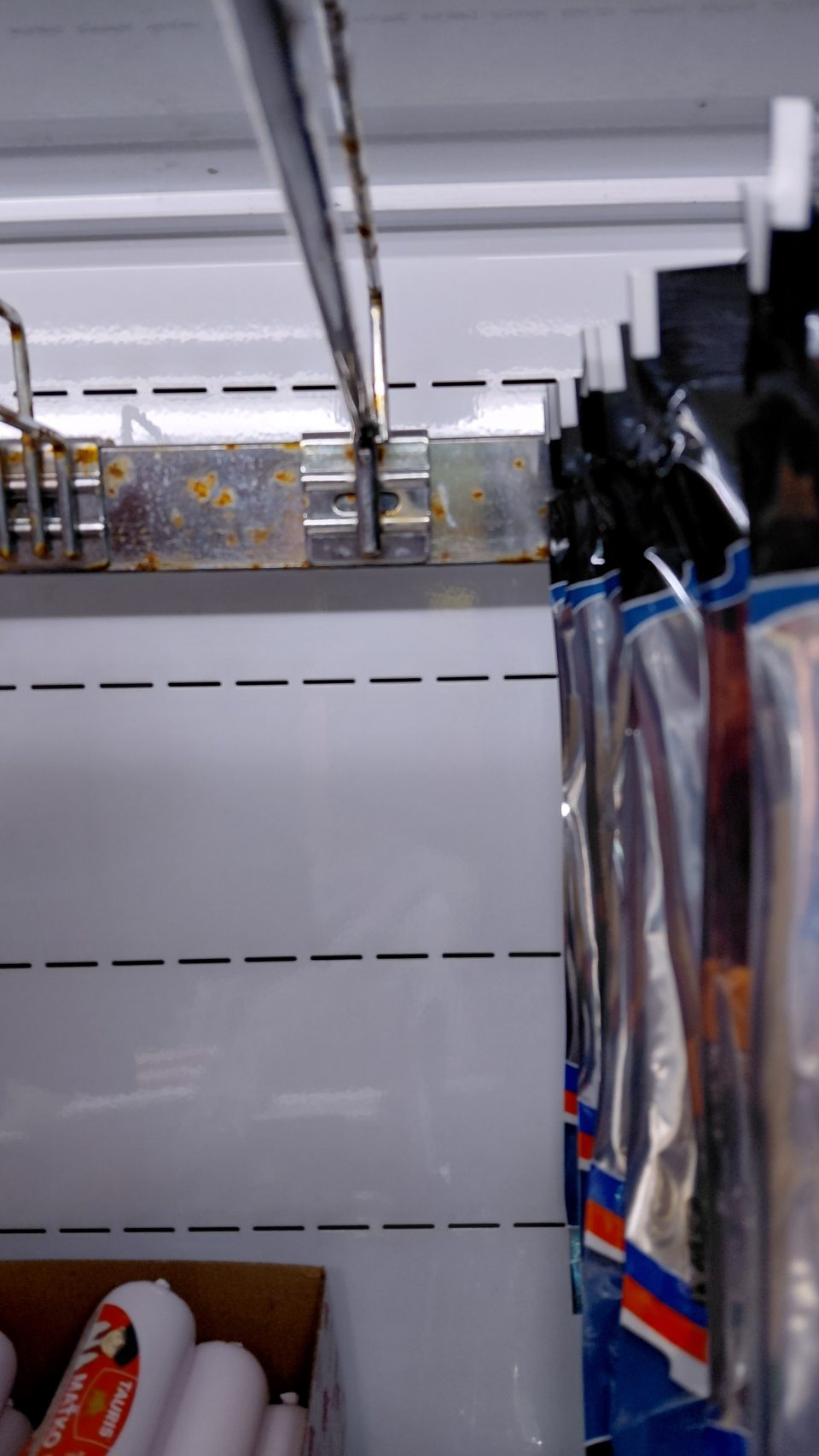 hrdzavý závesný systém v chladiacej vitríne pri predaji mäsových výrobkov