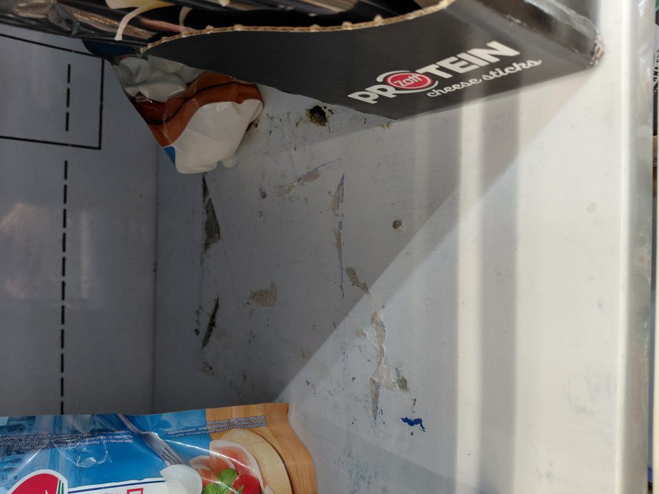 Znečistená polička chladiaceho zariadenia na mliečne výrobky