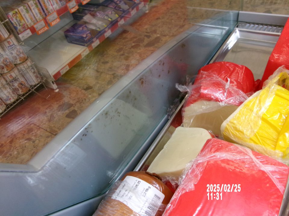 Zistená silne znečistená chladiarenská vitrína s uchovávanými mläsovými výrobkami na ťažko prístupnom mieste- medzi bočnou sklenenou stenou a kovovou konštrukciou