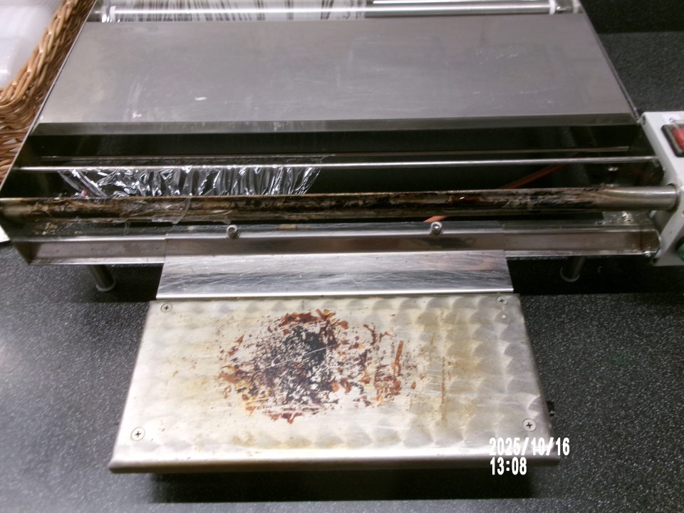 Zistené znečistené zariadenie, určené na balenie potravín, a to zvyškami pripálenej potravinárskej fólie v časti predaja čerstvého mäsa, mäsových výrobkov a lahôdkárskych výrobkov.