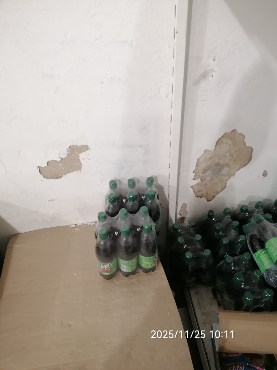 Olupujúca sa omietka steny pri regáloch s potravinami.