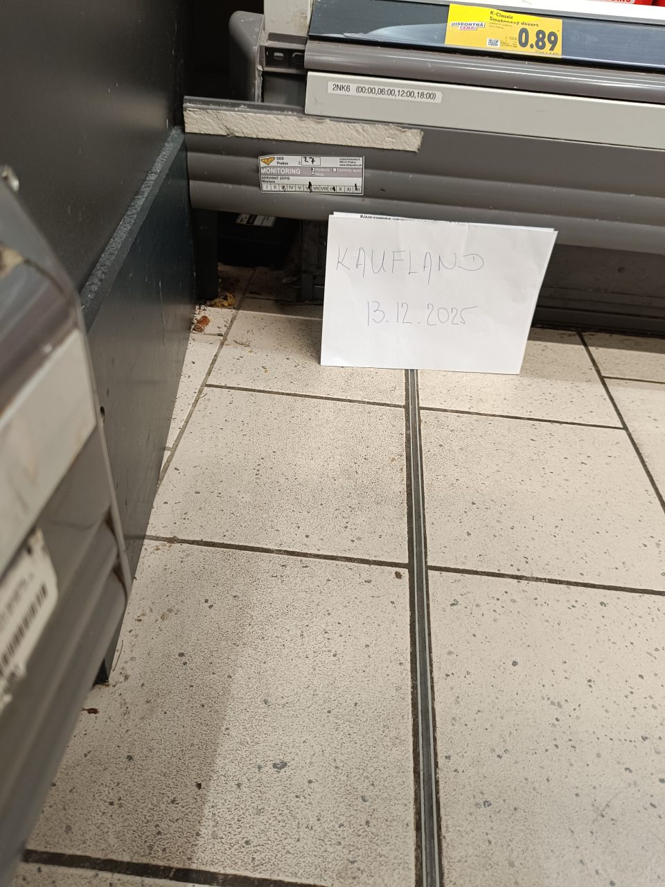 V rohu medzi chladiacimi vitrínami pre mliečne výrobky pri monitorovacej staničke pre hlodavce na podlahe prítomné hrubé, nečistoty, zvyšky obalového materiálu a zvyšok cigaretového ohorku ( filter)