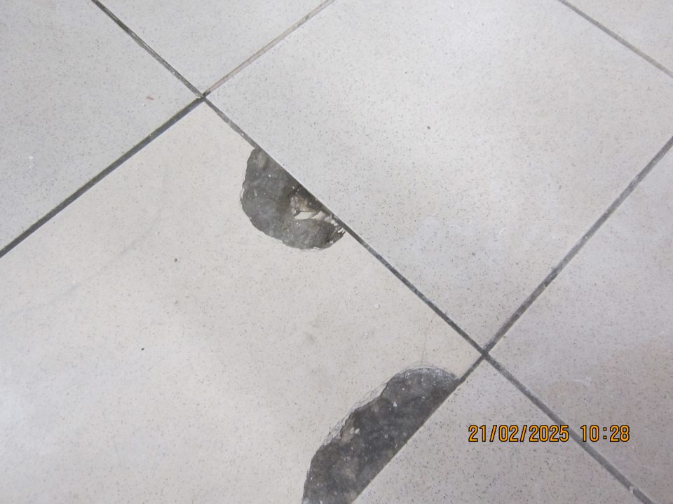 Poškodená dlažba v suchom sklade.