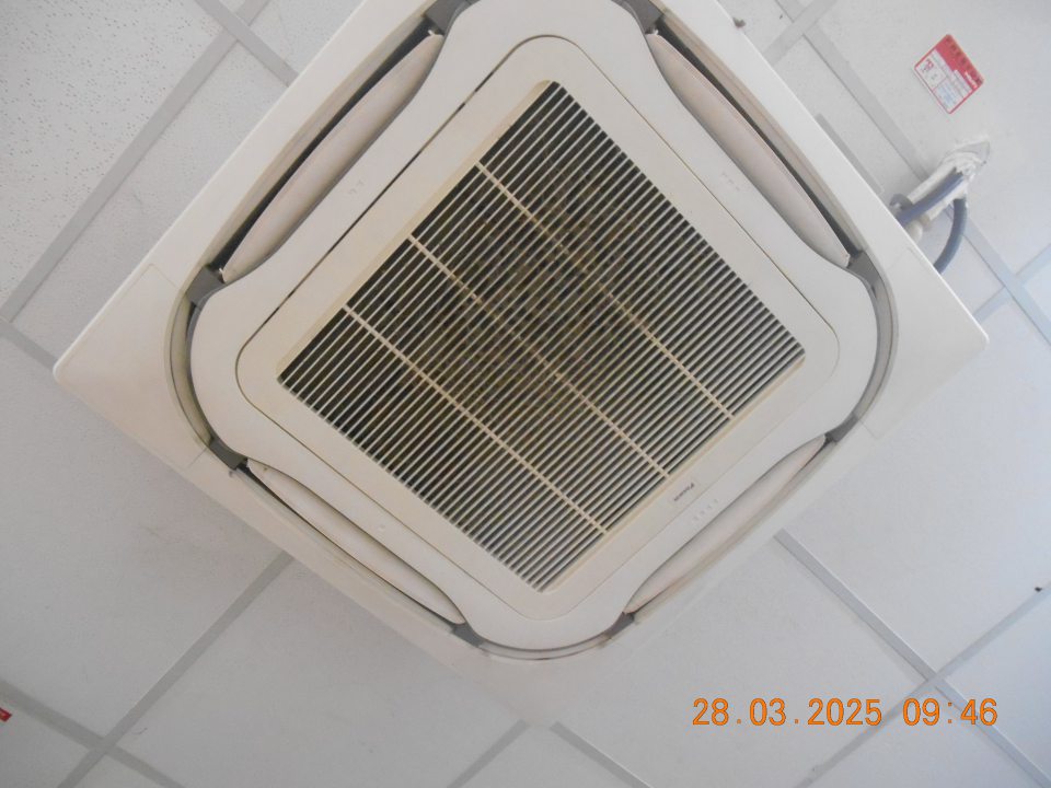 Mriežka klimatizačnej jednotky  na strope v skladovacej časti prevádzky znečistená vrstvou usadeného prachu a nečistôt.