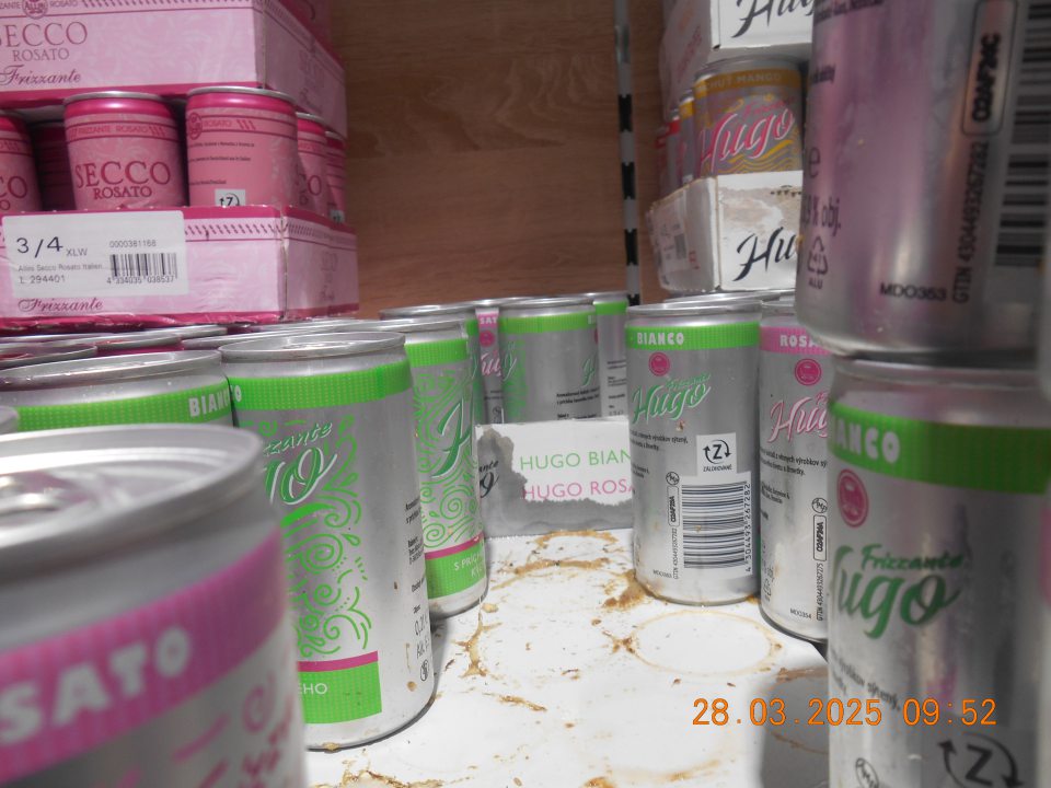 Regál na uchovávanie alkoholických nápojov v plechovkách na predajnej ploche prevádzky znečistený  vytečeným obsahom.
