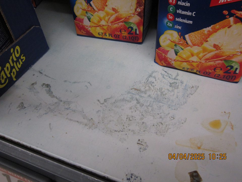 Regály určené na uchovávanie nealkoholických nápojov – džúsov na predajnej ploche znečistené zaschnutou čiernou špinou a prachom.