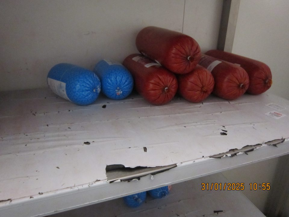 Olupujúca sa a znečistená fólia na regáli v chladiacom boxe na mäsové výrobky v skladovacích priestoroch prevádzky.