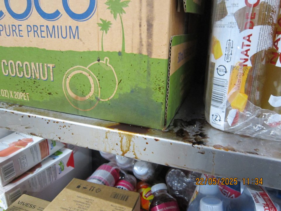 Regál na uchovávanie ochutených nealkoholických nápojov  v skladovacej časti  prevádzky  znečistený zaschnutými nečistotami z vytečeného obsahu z daných výrobkov. 