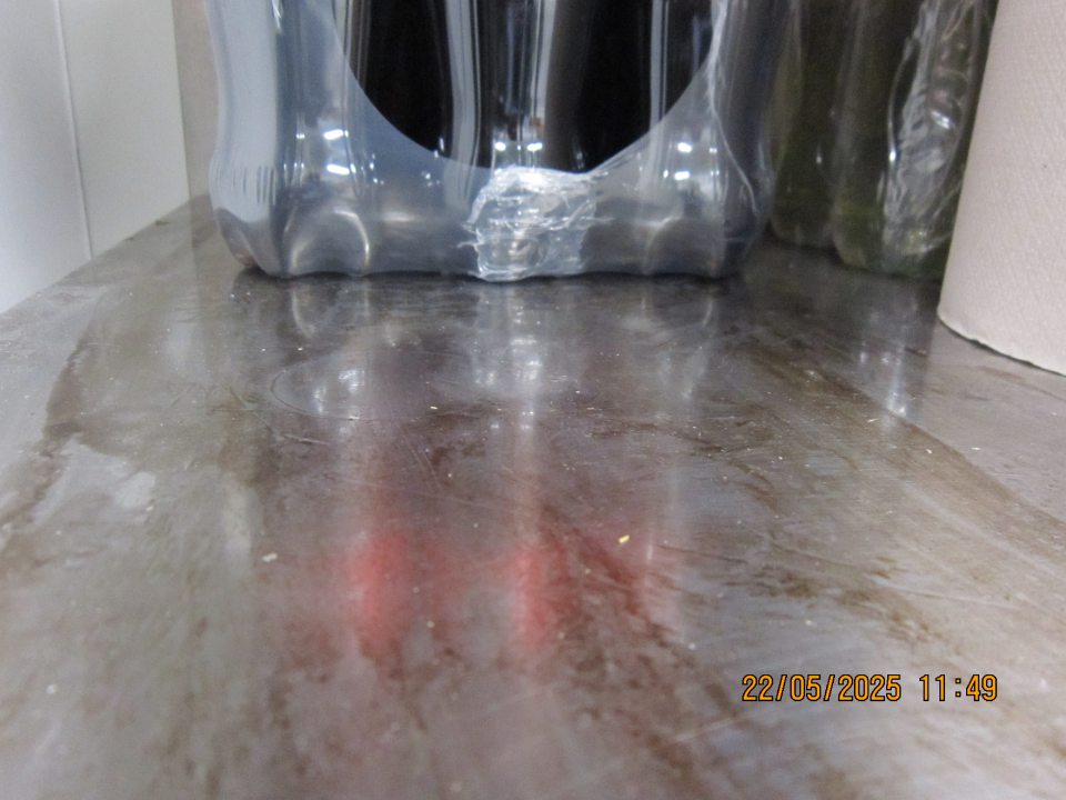 Regál na uchovávanie pepsi nápojov v skladovacej časti  prevádzky  znečistený zaschnutými nečistotami z vytečeného  obsahu z daných výrobkov.