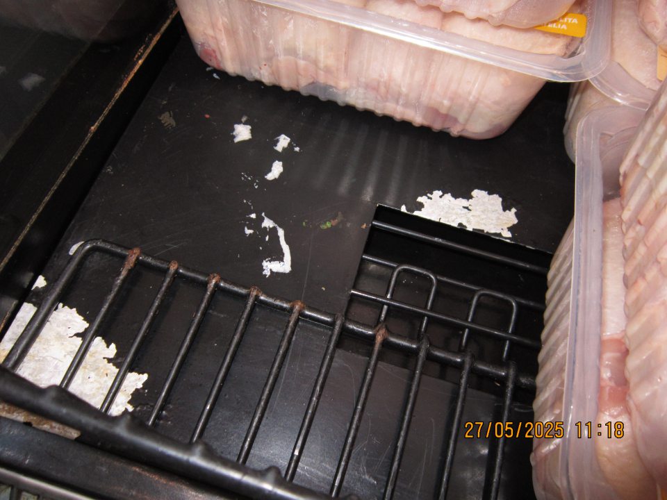 Hygiena zariadení – poškodený regál, olupujúci sa náter s výskytom hrdze v chladiacej vitríne na uchovávanie čerstvého hydinového mäsa. 