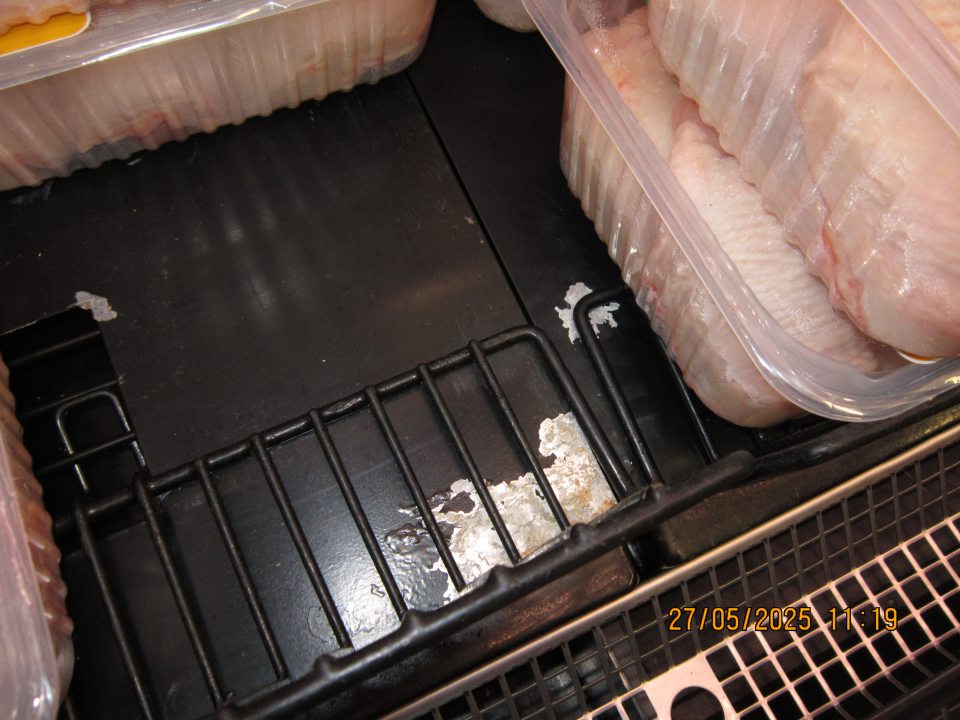 Hygiena zariadení – poškodený regál, olupujúci sa náter s výskytom hrdze v chladiacej vitríne na uchovávanie čerstvého hydinového mäsa. 