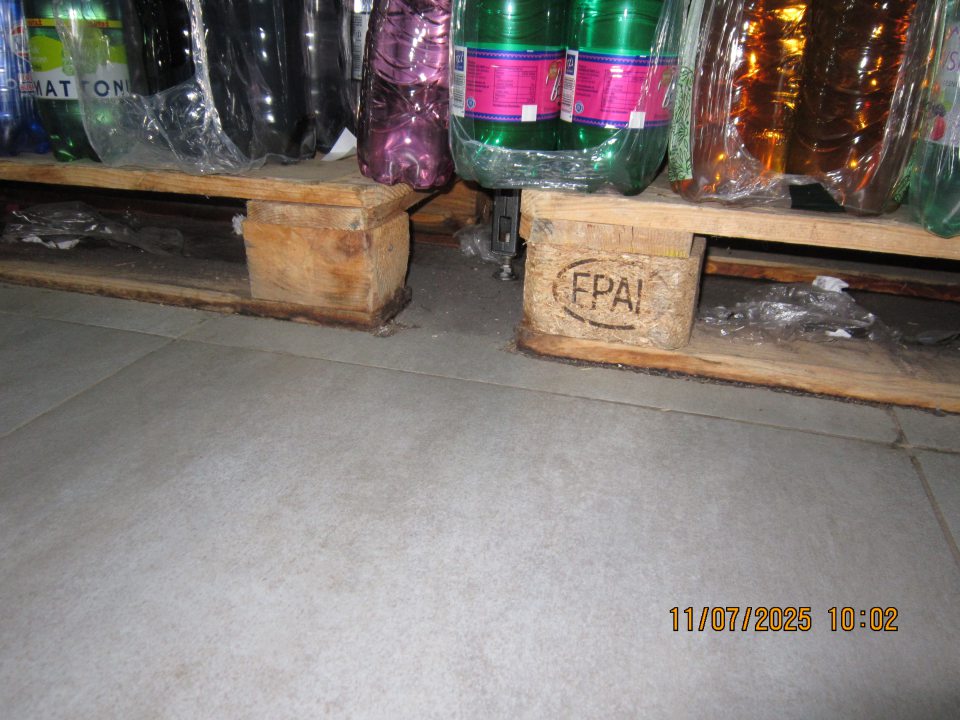 Na predajnej ploche - podlaha v priestore pod paletami s balenými nealko nápojmi znečistená nánosmi prachu, nečistotami a  zbytkami obalového materiálu. 