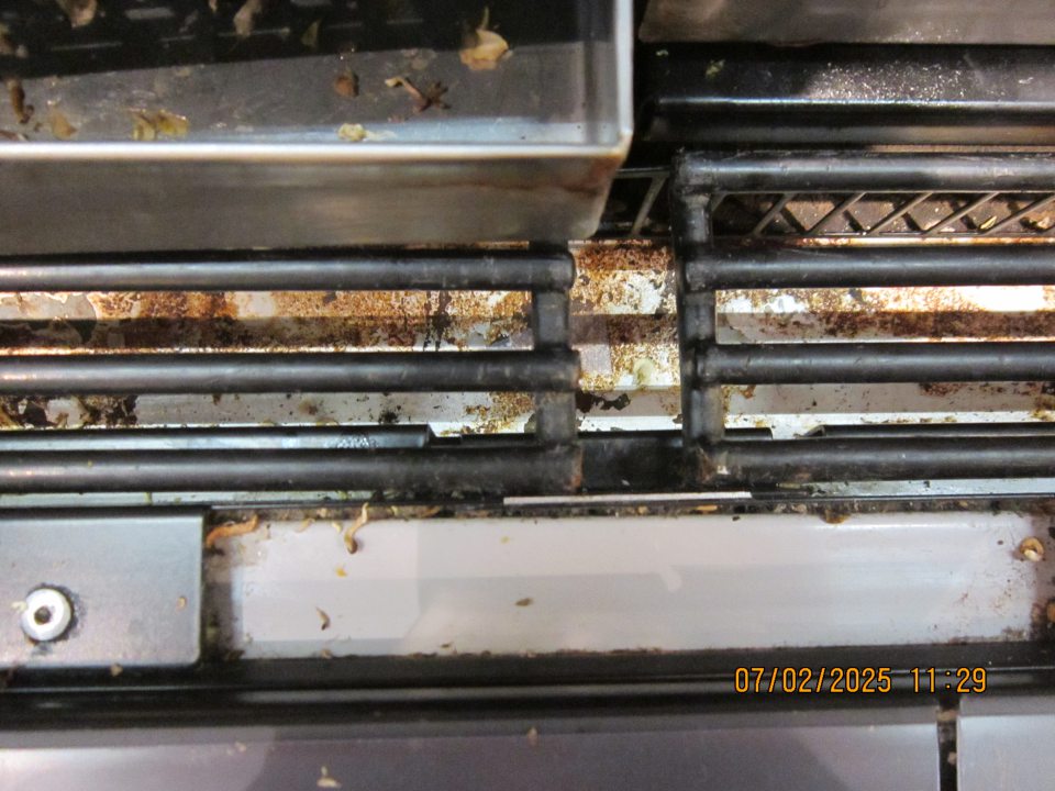 Na predajnej ploche v chladiarenskej vitríne na uchovávanie kvasenej kapusty a zeleniny silne skorodovaný kovový priestor pod mriežkami. 