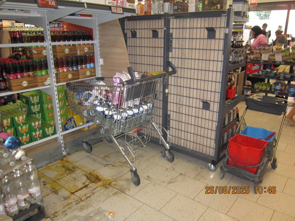 Nálepy čiernej špiny a zaschnutý vytečený obsah nealko nápojov na podlahe predajnej plochy prevádzky.