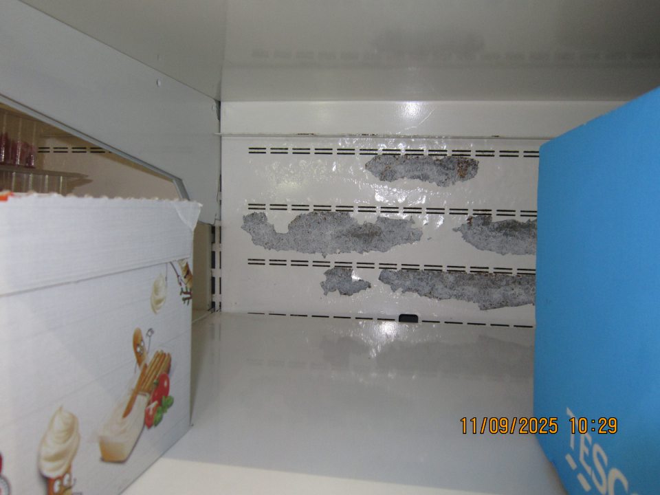 Poškodený, olupujúci sa hygienický náter a korózia zadnej steny chladiacej vitríny na uchovávanie čerstvého mäsa.