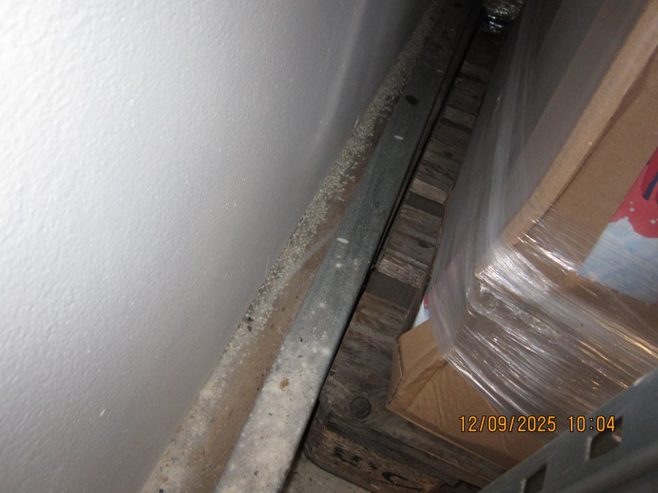 Rozsypaná múka a ryža pri stene za paletou s trvanlivým mliekom a múkou v priestoroch skladu v zázemí.