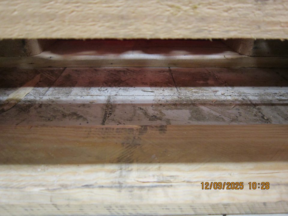 Podlaha na predajnej ploche pod paletami s kolovými nápojmi znečistená vrstvou špiny.