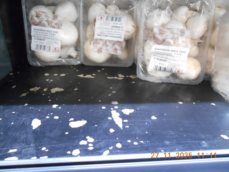 Poškodený povrch regálu - olupujúci sa čierny náter v chladiacej vitríne na uchovávanie chladenej zeleniny na predajnej ploche prevádzky.