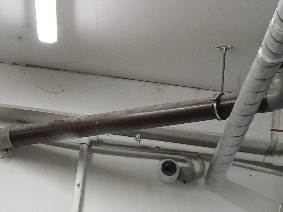 V suchom sklade potravín vedie znečistené/zaprášené potrubie pod stropom.