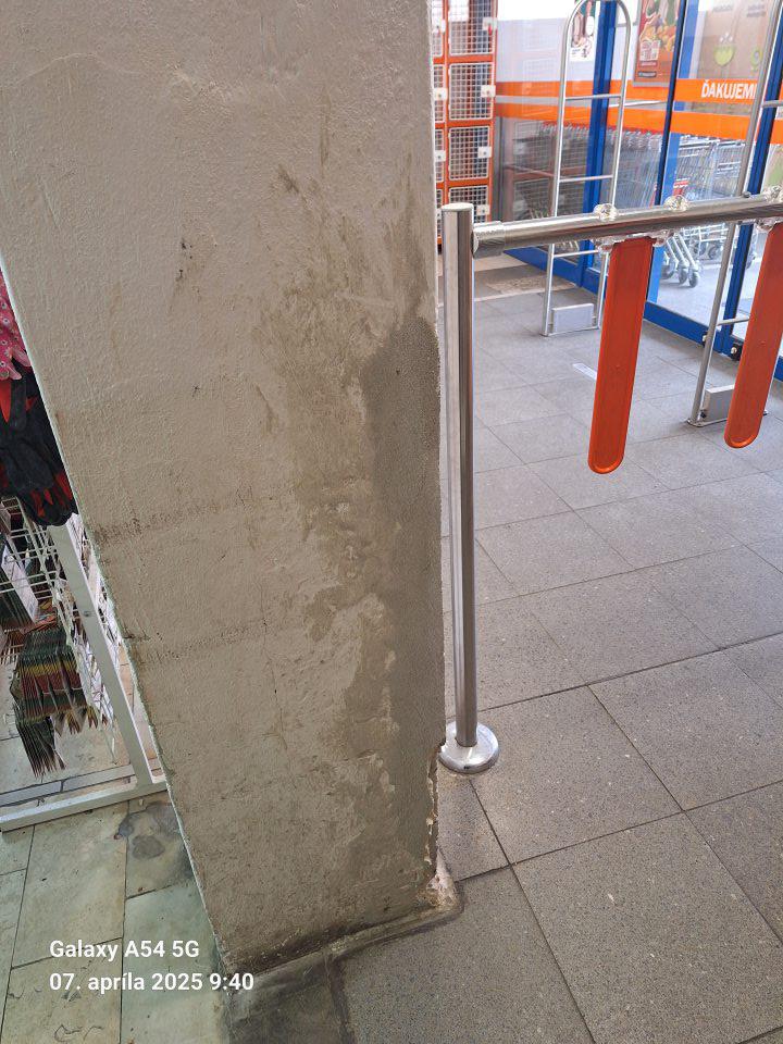 Zatečený stĺp a opadávajúca omietka na stĺpe v predajni.