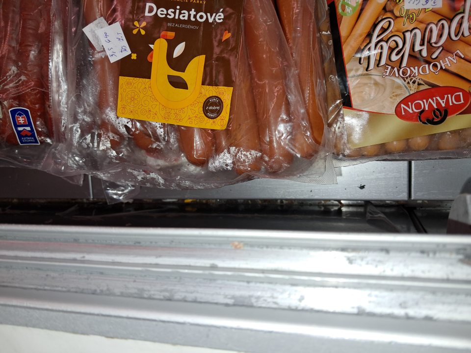 Znečistený priestor za táckou v chladiacej vitríne.