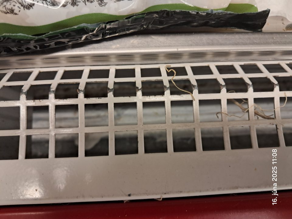 Napadané nečistoty pod mriežkou.