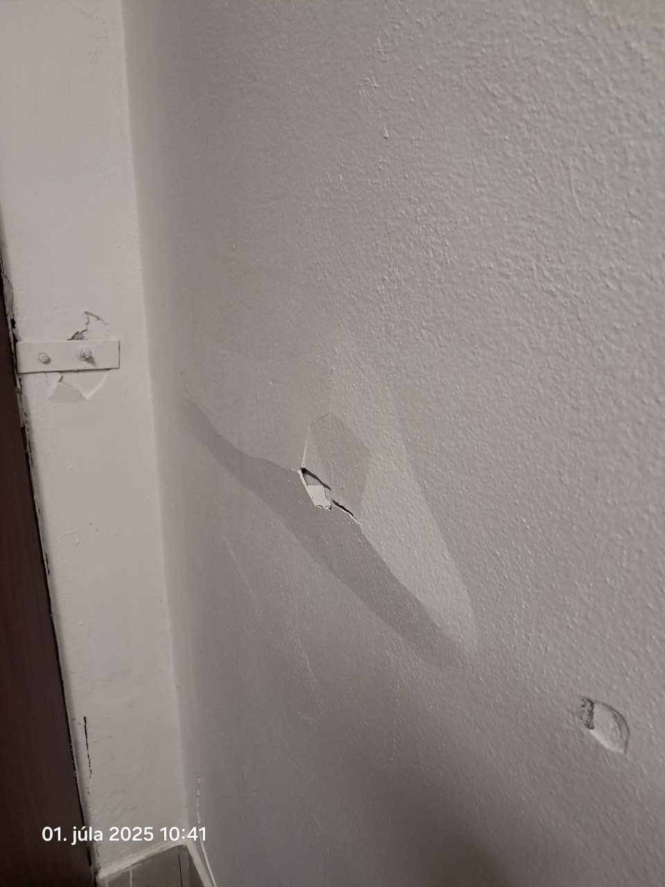 Poškodená stena v šatni.