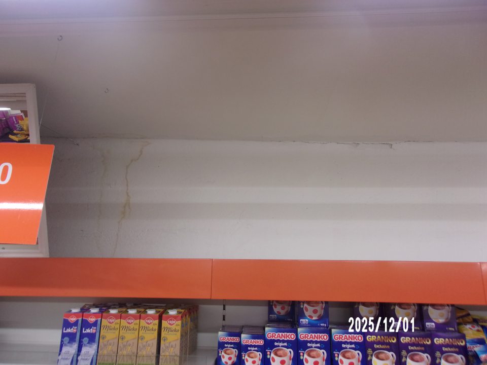 stena a strop predajnej časti prevádzkarne nad regálmi s vystavovanými trvanlivými potravinami sú poškodené zatečením, omietka sa olupuje a opadáva