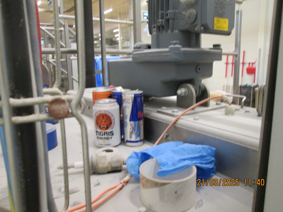 Na strojnotechnologickom zariadení zásobník na sirup, ktorý bol naplnený uložených 5 kusov obalov od energetických nápojov plných aj prázdnych.
