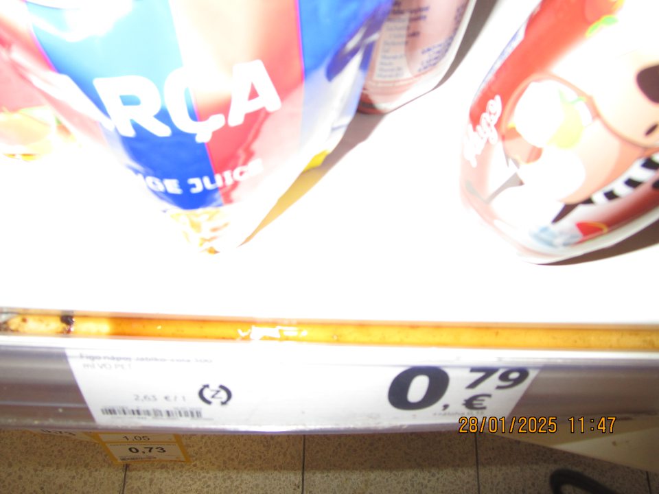 predajná plocha: na regáli s uskladnenými nealkoholickými nápojmi rozliata tekutina, rozmočený papierový kartón, vytečená tekutina rozliata v kovových zárezoch regála