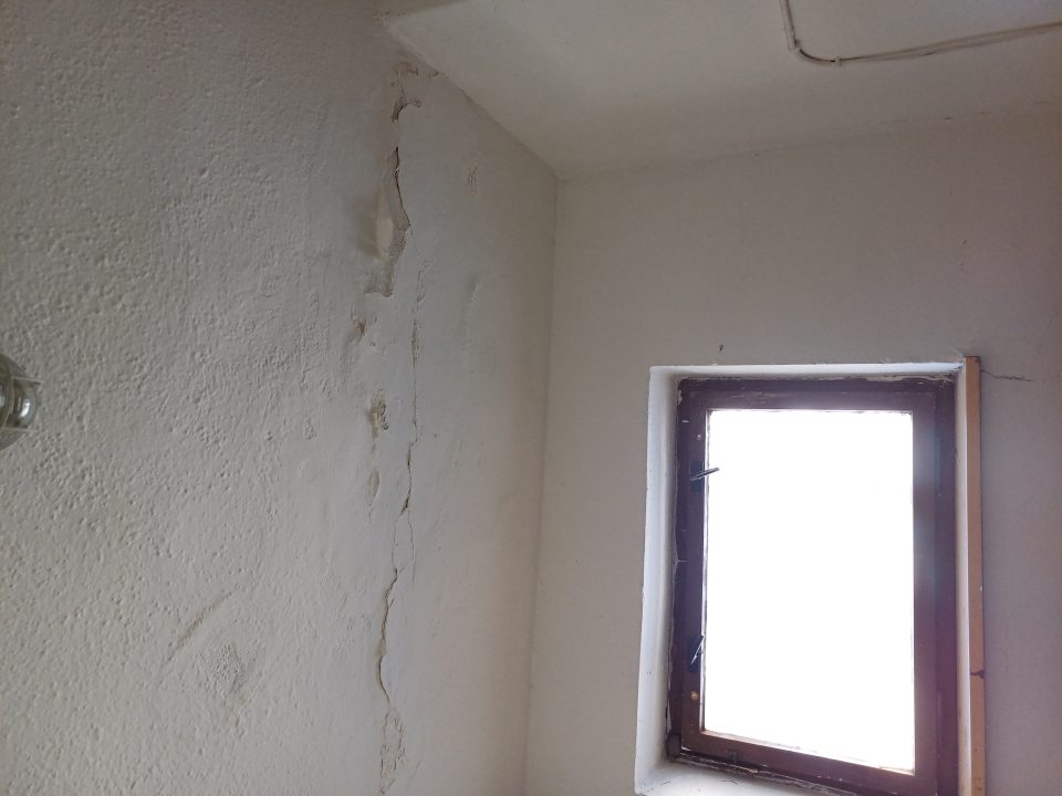 Stena v predsieni záchodu je poškodená, opadávajúca omietka, prasknutý strop. 