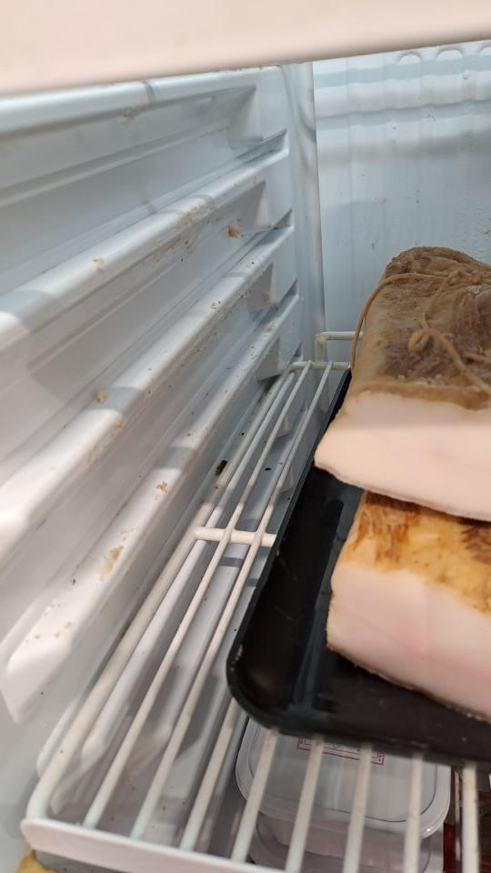 3. Znečistené steny a kovová mriežkovaná polica zvyškami potravín v chladiarenskej vitrína na mäsové výrobky.