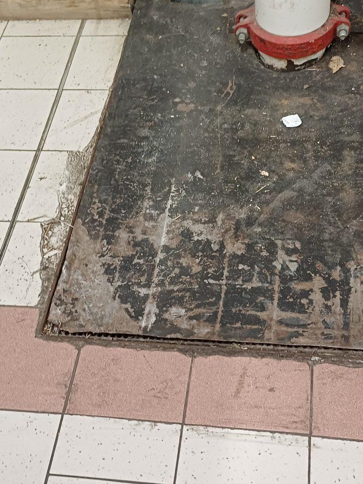 Podlaha v suchom sklade potravín poškodená znečistená.