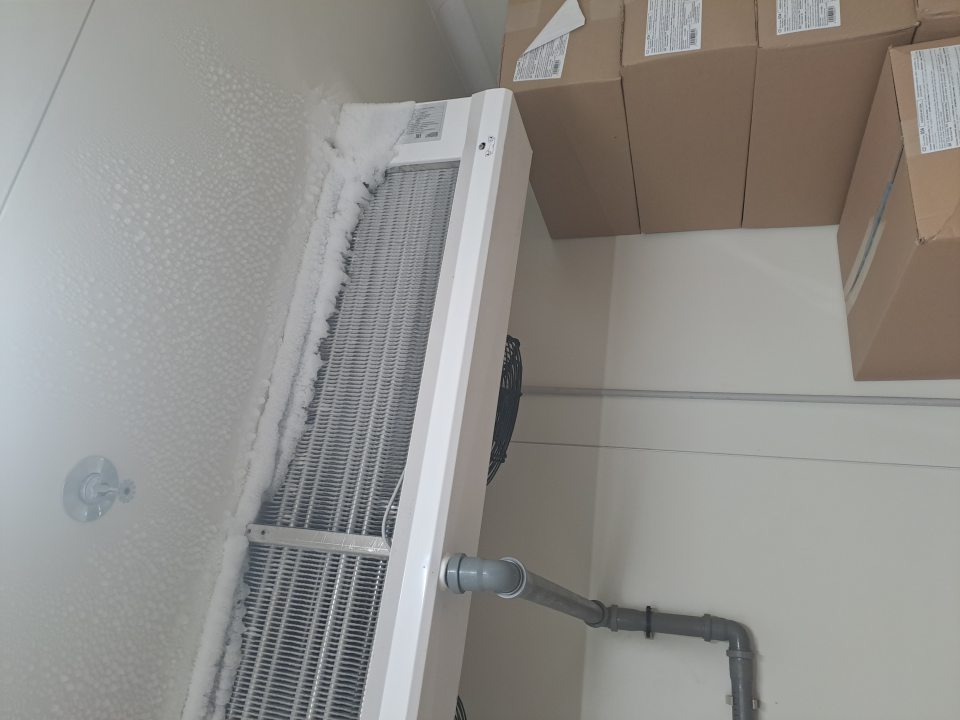 Mraziarenský sklad pečiva - poškodená zárubňa dverí z oboch strán a zamrznutý kondenzát na plastových lamelách vstupu do skladu, v sklade poškodený obvodový sokel pri vstupných dverách, znečistená podlaha pri vstupe, námraza na strope