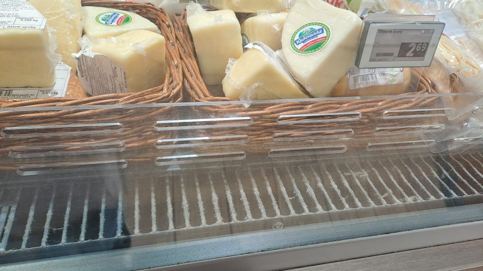 V chladiacom zariadení s ponukou balených syrov zaprášená predná mriežka.