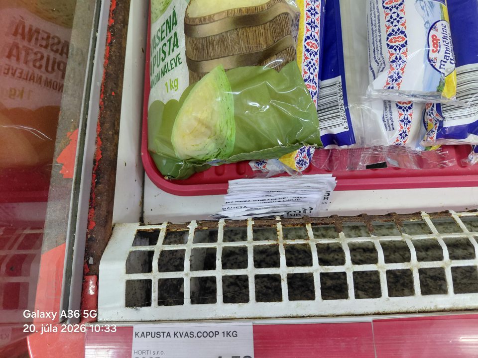 znečistený priestor pod mriežkou chladiacej vitríny určenej na predaj mliečnych výrobko, vajec, parený knedlí, hrdzavá mriežka olupujúci sa náter