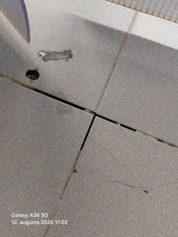 Podlaha na predajnej ploche a v skladových priestoroch poškodená - vypadaná škárovačka medzi dlaždicami, rozbité dlaždice, výtlky