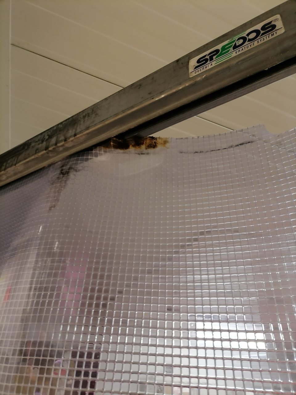 Poškodený umelohmotný záves pri vstupe do chladiaceho boxu